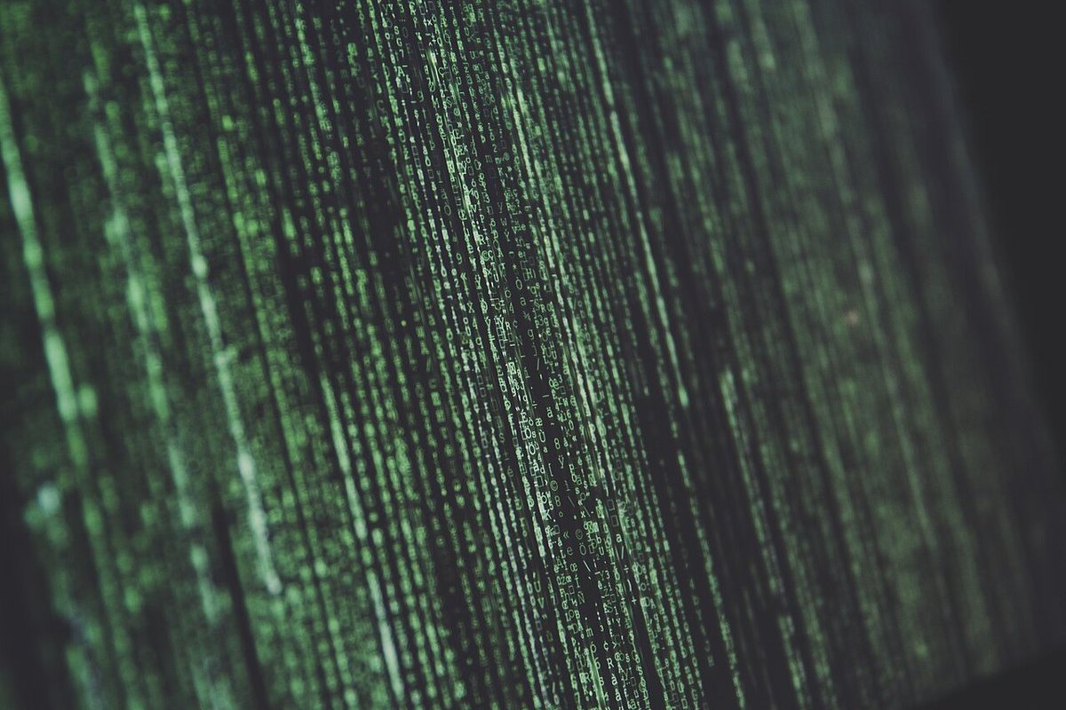 Green code scrolling on a laptop screen in the dark