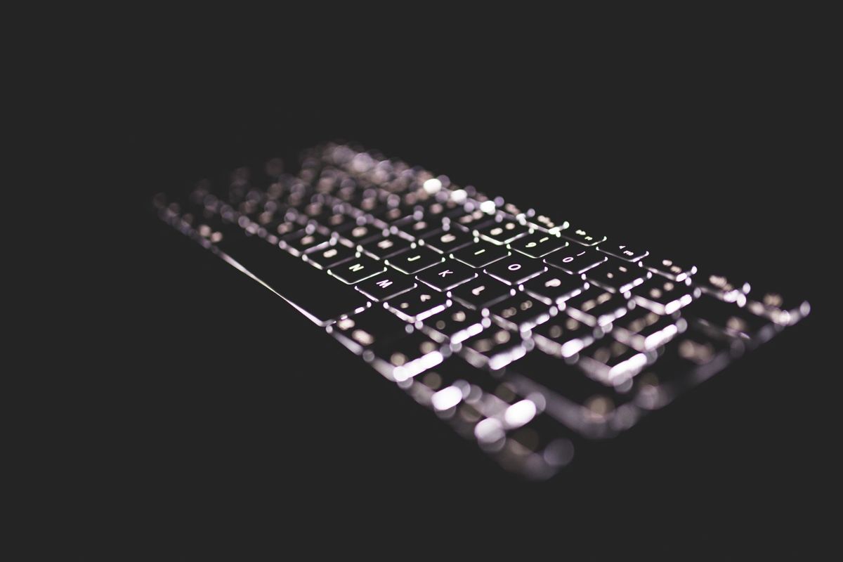 Backlit laptop keyboard in a dark room, illustrating an Ohio online sting investigation